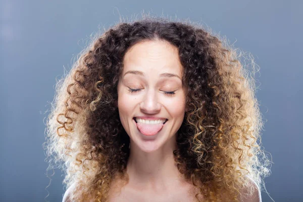 Krásná Dívka Dlouhými Kudrnatými Vlasy Portrét Vtipný Výraz Vyplazeným Jazykem — Stock fotografie