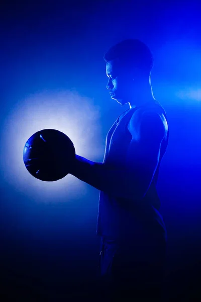 Jugador Baloncesto Sosteniendo Una Pelota Contra Fondo Niebla Azul Silueta —  Fotos de Stock