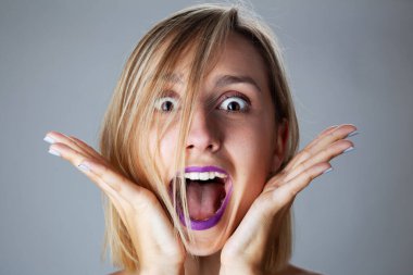 Güzel sarışın kız stüdyo resmi. El hareketleriyle şaşırmış yüz ifadesi..