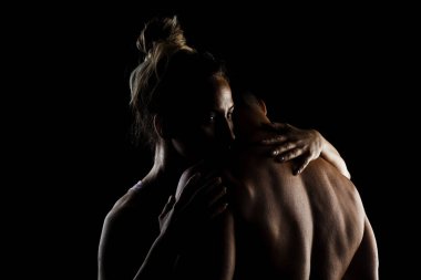 Uygun çift birlikte poz veriyor. Erkek ve kız tarafı siyah arka planda aydınlık siluetler..