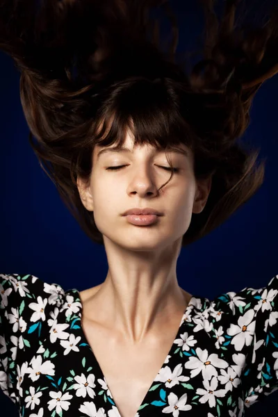 Hermosa Joven Posando Estudio Sobre Fondo Azul Oscuro Cabello Aire —  Fotos de Stock