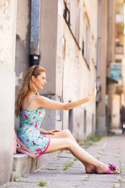 Dziewczyna Siedzi Chodniku Robi Sobie Selfie Telefonem — Zdjęcie stockowe