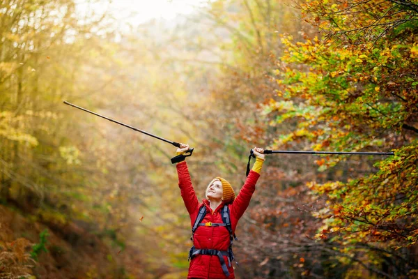 歩道にポールとバックパックを持つハイキングの女の子 自然の中でお楽しみください 秋のアウトドア旅行と健康的なライフスタイル — ストック写真