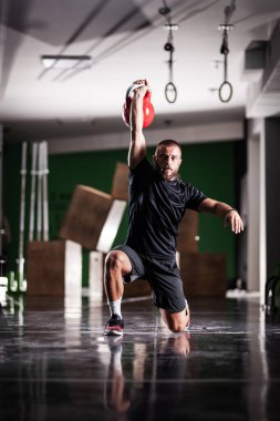 Kettlebell 'i kaldıran kaslı atlet gücü. Adam içeride çalışıyor..