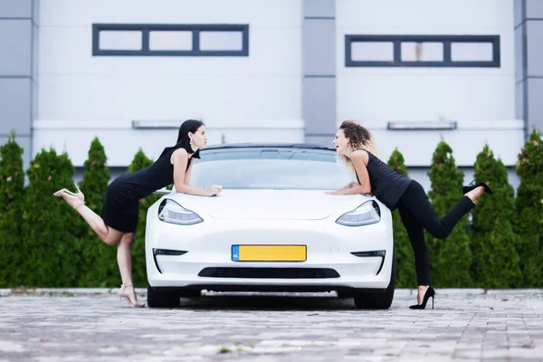 Две Красивые Девушки Черные Outfut Позируя Современной Белой Машиной Городской — стоковое фото