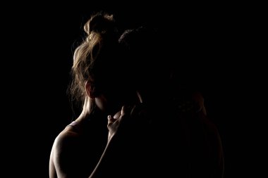 Uygun çift birlikte poz veriyor. Erkek ve kız tarafı siyah arka planda aydınlık siluetler..