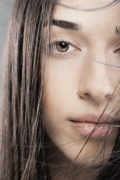 美少女のファッションスタジオポートレート風の強い髪の少女の顔の前 — ストック写真