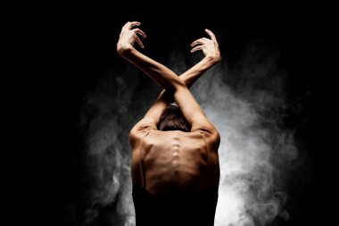 Yarı siluet modern balerin esmer arka planda dumanla poz veriyor.