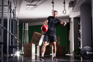 Kettlebell 'i kaldıran kaslı atlet gücü. Adam içeride çalışıyor..