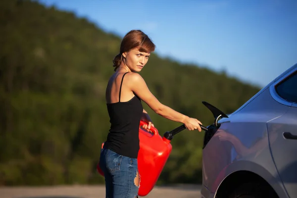 Μπερδεμένο Κορίτσι Προσπαθεί Βάλει Βενζίνη Από Ένα Κόκκινο Κάνιστρο Ένα — Φωτογραφία Αρχείου