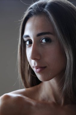 Güzel esmer kız stüdyo resmi. Ciddi yüz ifadesi.