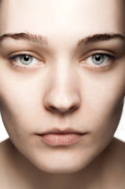 Beyaz arka plana karşı güzel bir genç kadının stüdyo portresini kapat.