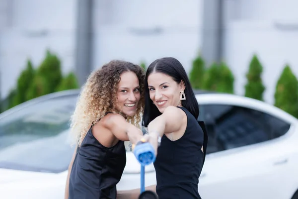 Δύο Όμορφες Επιχειρηματίες Μαύρα Ρούχα Ποζάρουν Μπροστά Από Ένα Ηλεκτρικό — Φωτογραφία Αρχείου