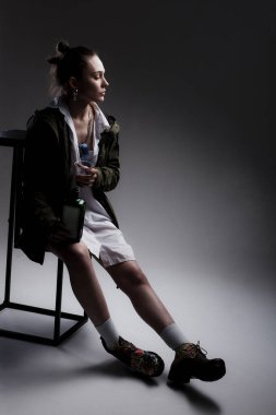 Alkol şişesi ve plastik bardağı olan güzel bir kızın stüdyo portresi..