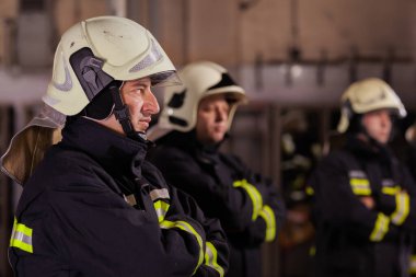 Profesyonel itfaiyeciler bir arada. İtfaiyeciler üniforma ve koruyucu kask takıyor..