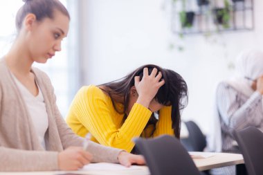 Sınıfta sınava giren öğrenciler. Zeki genç kız bilgisiyle hayal kırıklığına uğradı..