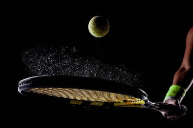 Tenis topu rakette zıplıyor. Toprak ya da magnezyum tozları havada görünür..