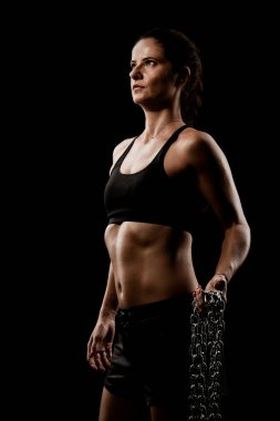 Metal zincirli, formda bir kız. Siyah arkaplan üzerinde çekme ve poz