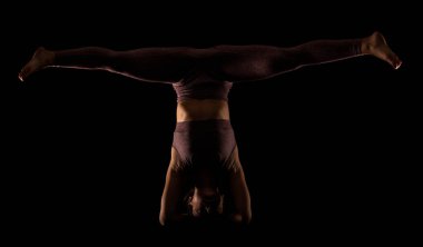 Yoga pozu veren zinde bir kadın. Stüdyoda siyahlara karşı egzersiz yapan yarım siluet kız..