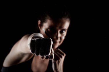 Kickboxer kirl 'ün ellerinde magnezyum tozu görünür tozla vuruyor..