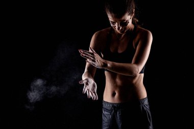 Kickboxer kirl 'ün ellerinde magnezyum tozu görünür tozla vuruyor..