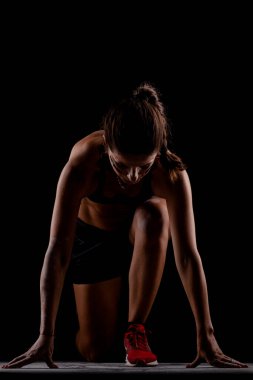 Yandan aydınlatılmış siluet formundaki kız yarışa koyu arkaplanda başlıyor..