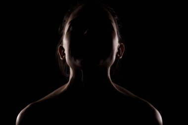 Yandan aydınlık siluet bir resim güzel bir genç kadının karanlık arka planda karşı karşıya