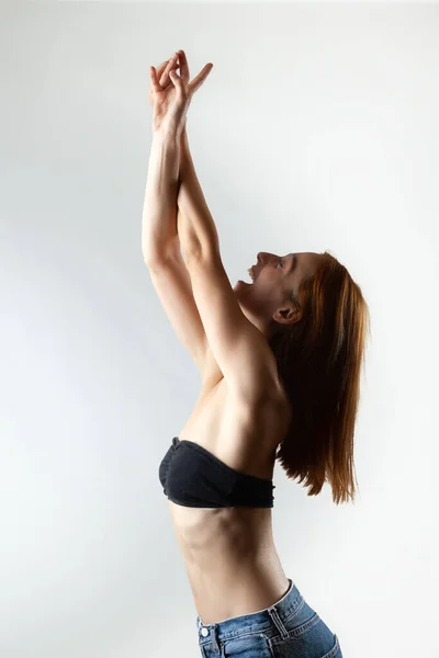 一个漂亮的女孩 留着烧焦的橙色头发 伸展着身子 摆出芭蕾舞的姿势 灰色背景的工作室肖像 — 图库照片