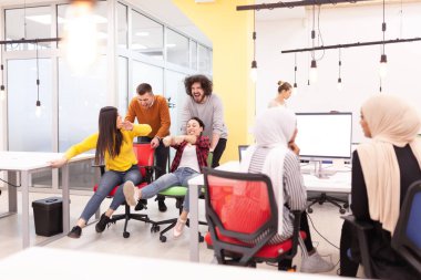 İş arkadaşları iş yerinde eğleniyorlardı. Tekerlekli sandalyedeki erkekleri iten kızlar. Çok ırklı başarılı bir şirket kurma grubu