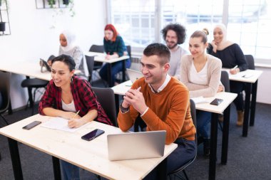 Sınıfta bir öğretim üyesini dinleyen çok ırklı öğrenciler. Zeki gençler üniversitede okuyor..