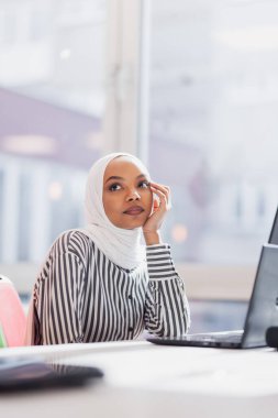 Ofiste dizüstü bilgisayarla çalışan Afrikalı Müslüman bir kız..