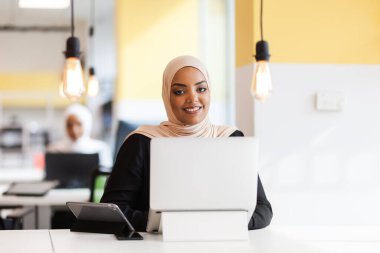 Ofiste dizüstü bilgisayarla çalışan Afrikalı Müslüman bir kız..