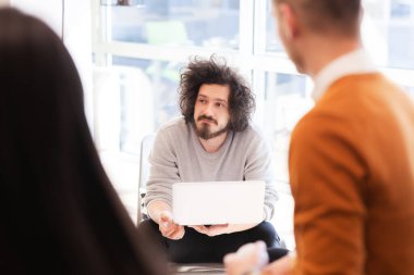 Genç ve başarılı insanlar yaratıcı bir toplantıda beyin fırtınası yapıyorlar. Girişim şirketinde takım çalışması.