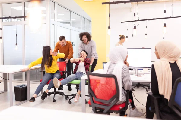 İş arkadaşları iş yerinde eğleniyorlardı. Tekerlekli sandalyedeki erkekleri iten kızlar. Çok ırklı başarılı bir şirket kurma grubu