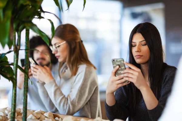 Barátok Ülnek Egy Kávézóban Telefonokat Néznek — Stock Fotó