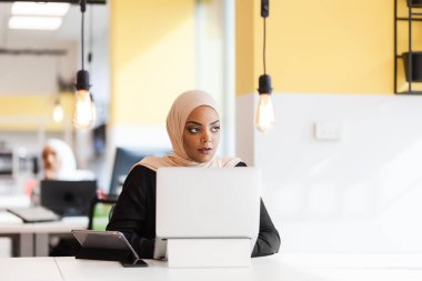 Ofiste dizüstü bilgisayarla çalışan Afrikalı Müslüman bir kız..