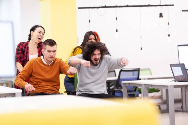 İş arkadaşları iş yerinde eğleniyorlardı. Tekerlekli sandalyedeki erkekleri iten kızlar. Çok ırklı başarılı bir şirket kurma grubu