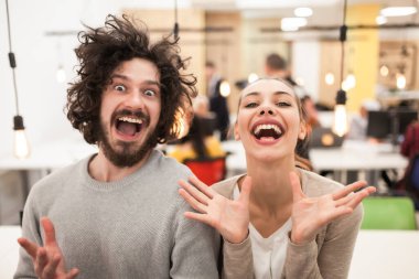 Dost canlısı iş arkadaşları modern ofis ortamında aylaklık ediyorlar. Hoş bir çift komik yüz ifadeleri yapıyor..