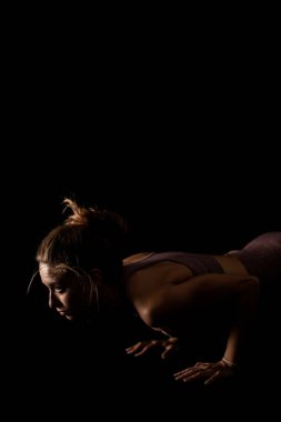 Yoga pozu veren zinde bir kadın. Stüdyoda siyahlara karşı egzersiz yapan yarım siluet kız..