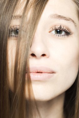 Kameraya bakarak mutlu bir yüz ifadesi olan güzel esmer bir kızın stüdyo portresini kapat..