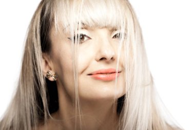 Sarışın, püsküllü güzel bir esmer kızın portresi. Düşen saçların ardından gülümseyen mutlu yüz ifadesi.