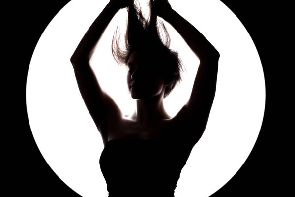 Silhouette portrait of a girl with short hair and hands up. Isolated against white background