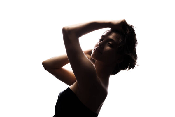 Half silhouette portrait of a girl with short hair and hands up. Isolated against white background