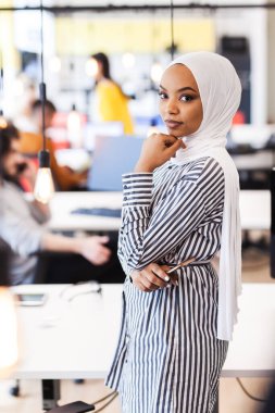 Modern bir ofiste başarılı genç insanlardan oluşan yaratıcı bir ekip. Başörtüsü olan güzel bir müslüman kızın portresi.