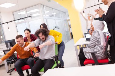 İş arkadaşları iş yerinde eğleniyorlardı. Tekerlekli sandalyedeki erkekleri iten kızlar. Çok ırklı başarılı bir şirket kurma grubu