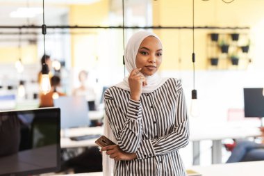 Modern bir ofiste başarılı genç insanlardan oluşan yaratıcı bir ekip. Başörtüsü olan güzel bir müslüman kızın portresi.