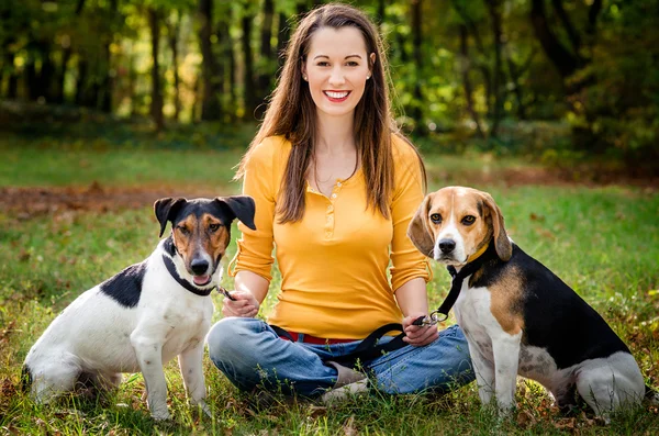 En vacker kvinna och hans hundar poserar utanför — Stockfoto