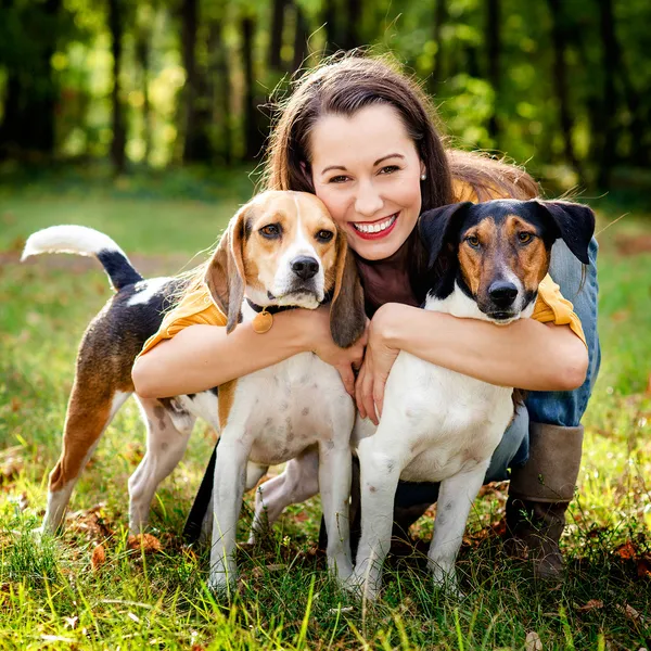 Een mooie vrouw en zijn honden poseren buiten — Stockfoto