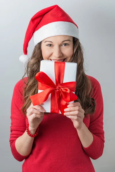 Christmas woman holding gifts wearing Santa hat — Stock Photo, Image