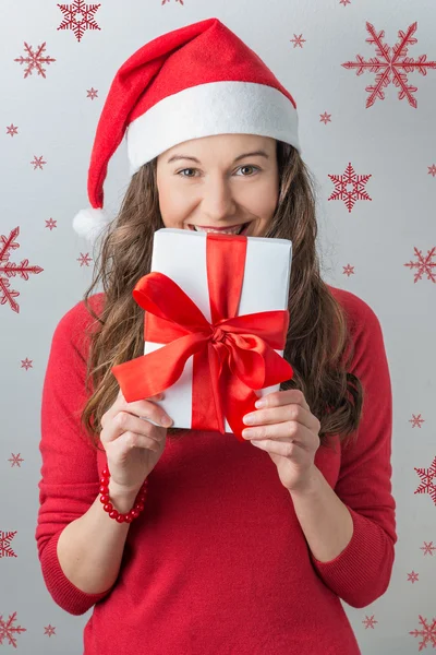 サンタ帽子をかぶっている贈り物を保持しているクリスマスの女性 — ストック写真